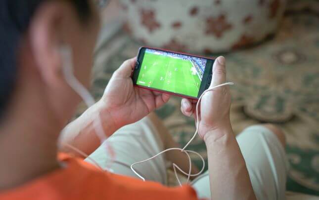watching football on a phone with headphones