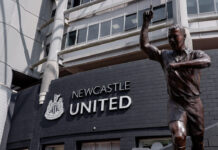 Bronze statue of Alan Shearer with one arm raised outside St James’ Park, Newcastle