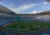 Wide view across the pitch and sky-blue stands at Coventry Building Society Arena