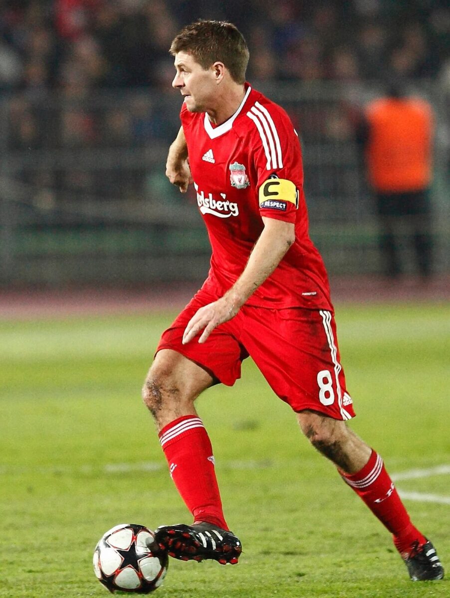 Steven Gerrard wearing the Liverpool captain’s armband Steven Gerrard controlling the ball in Liverpool’s red kit, wearing the captain’s armband
